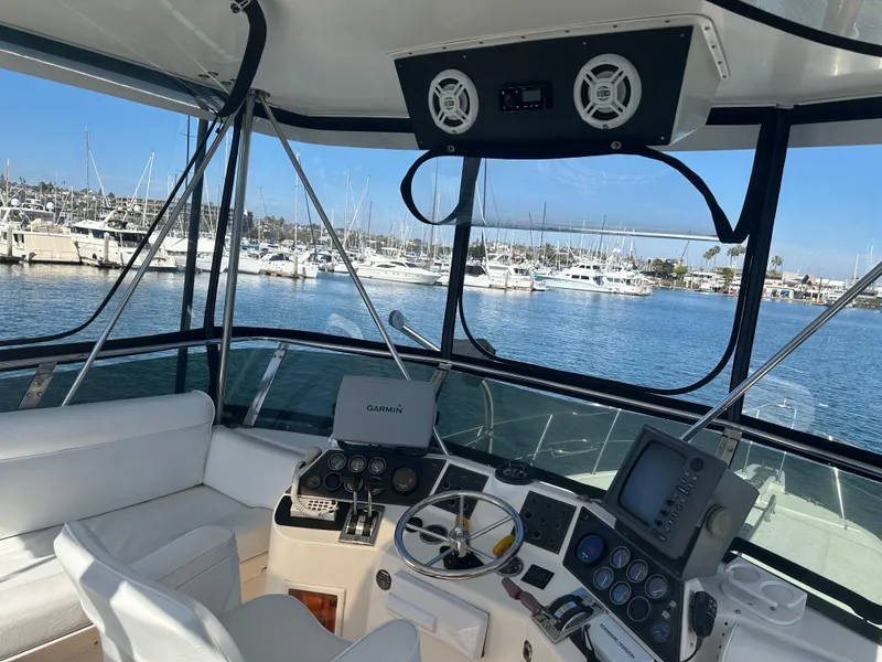 Slide: The Image of Cockpit of 1991 Symbol 39 Sedan Sportfisher with marina view, featuring navigation equipment. - 12