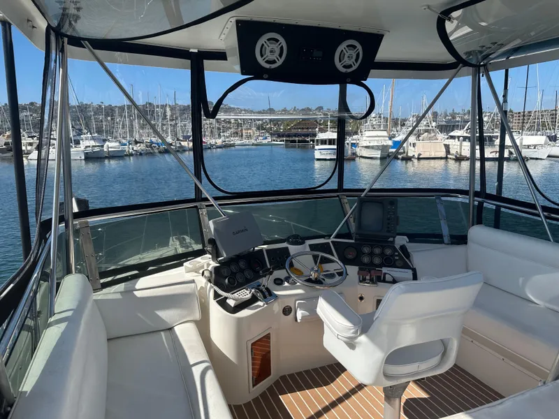 Slide: The Image of 1991 Symbol 39 Sedan Sportfisher boat interior with helm, seating, and marina view. - 13