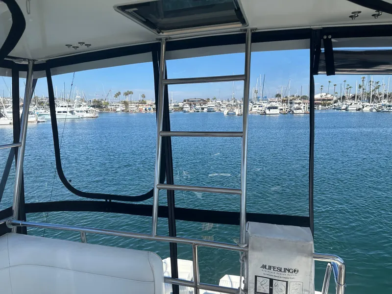 Slide: The Image of 1991 Symbol 39 Sedan Sportfisher interior with marina view, featuring ladder and seating. - 17