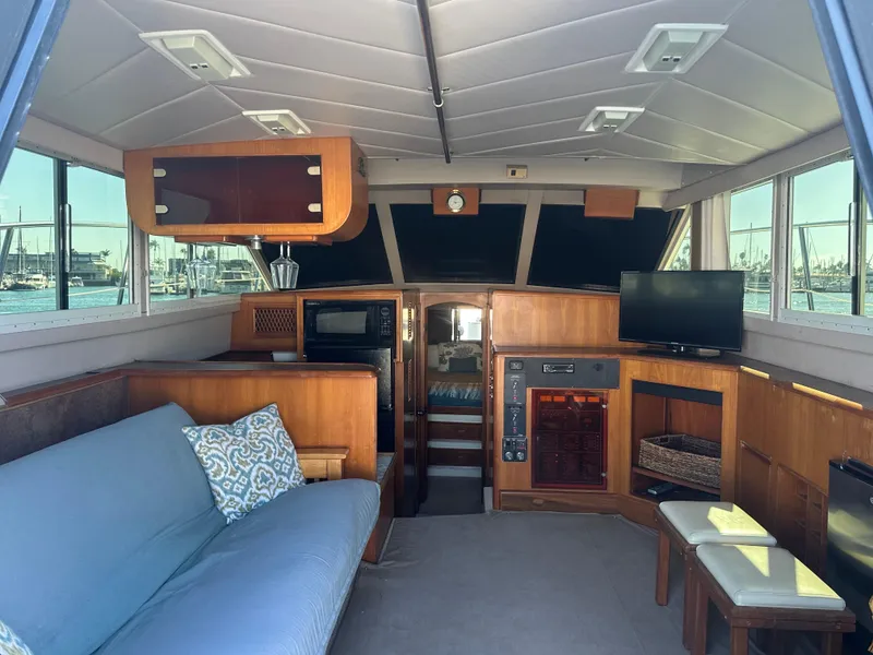 Slide: The Image of Interior of a 1991 Symbol 39 Sedan Sportfisher with cozy seating and wooden cabinetry. - 19