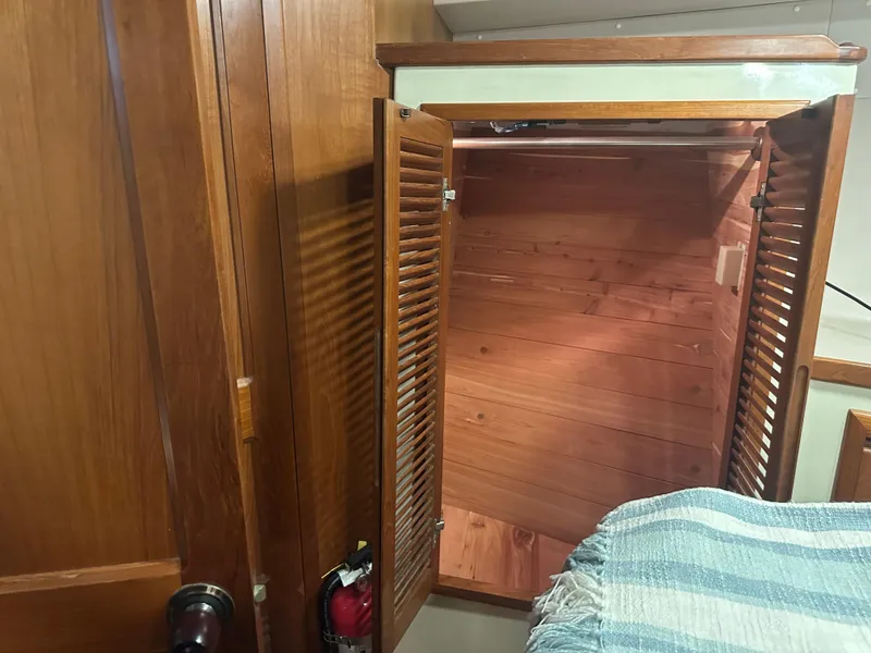 Slide: The Image of Wooden interior of 1991 Symbol 39 sedan sportfisher with open closet and fire extinguisher. - 24