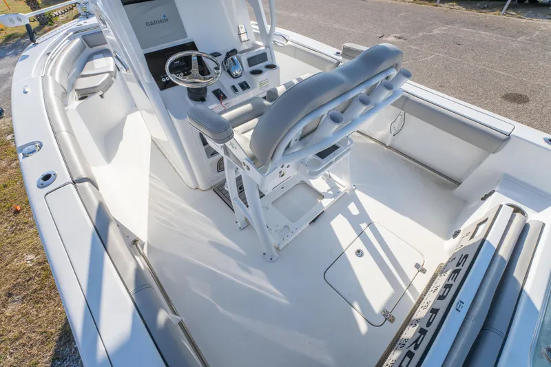 Slide: The Image of 2019 Sea Pro 239 DLX boat interior with helm, seating, and controls. - 12