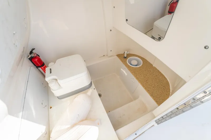 Slide: The Image of 2019 Sea Pro 239 DLX boat interior with portable toilet and fire extinguisher. - 28