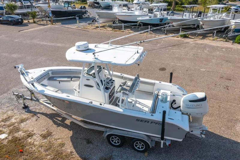 Slide: The Image of 2019 Sea Pro 239 DLX boat on trailer, parked in a marina with other boats. - 29