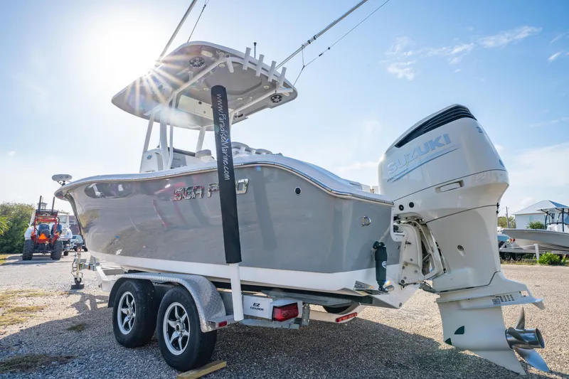 Slide: The Image of 2019 Sea Pro 239 DLX boat on trailer, sunlit, with powerful outboard motor. - 5