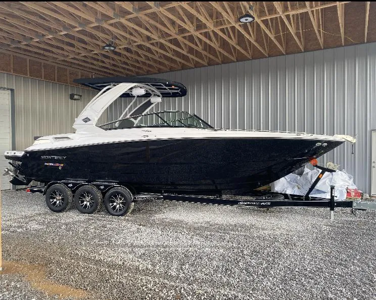 Slide: The Image of 2023 Monterey 298 Super Sport boat on trailer in a covered storage area. - 1