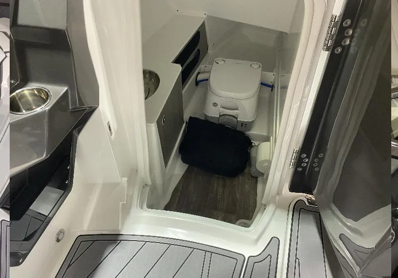 Slide: The Image of Interior of 2023 Monterey 298 Super Sport boat featuring compact bathroom amenities. - 12