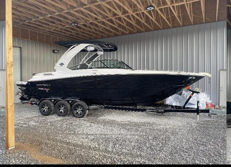 Slide: The Image of 2023 Monterey 298 Super Sport boat on trailer in covered storage area. - 2