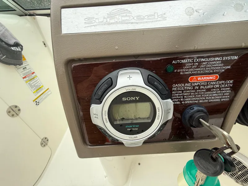 Slide: The Image of 2012 Sea Ray 280 Sundeck dashboard with Sony stereo and safety warnings. - 11