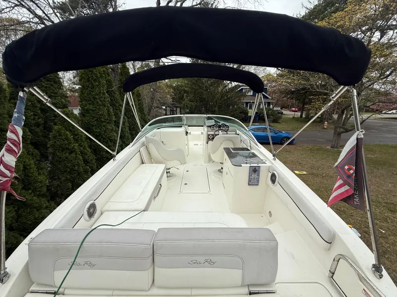 Slide: The Image of 2012 Sea Ray 280 Sundeck boat with canopy and seating, docked outdoors. - 19