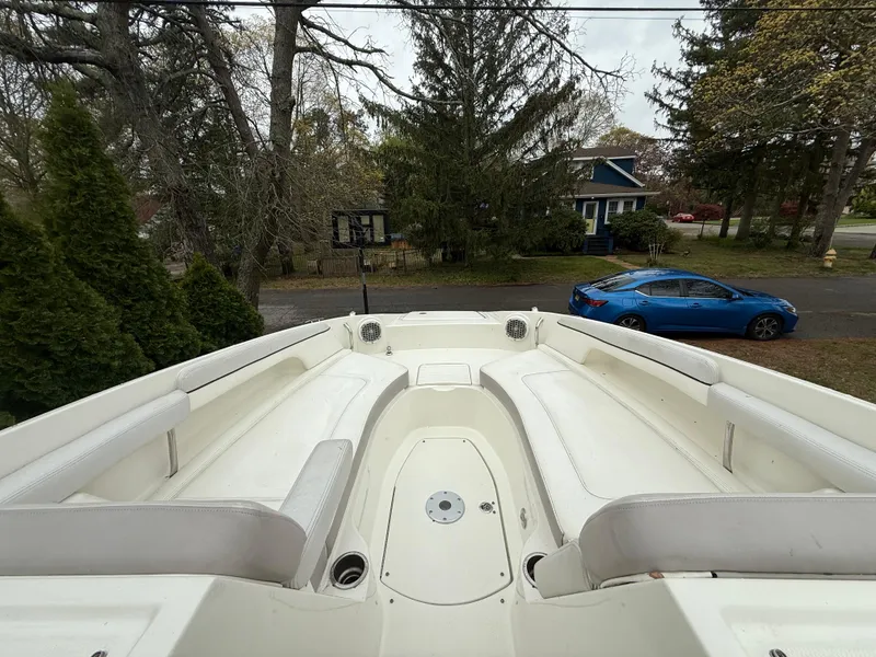 Slide: The Image of 2012 Sea Ray 280 Sundeck boat with spacious seating, parked in a residential area. - 2