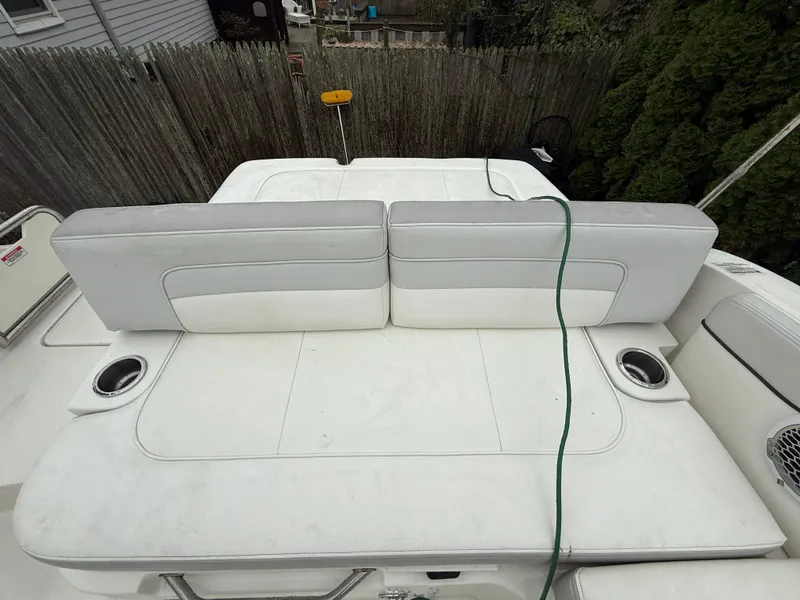 Slide: The Image of 2012 Sea Ray 280 Sundeck boat with white cushioned seating and cup holders. - 21