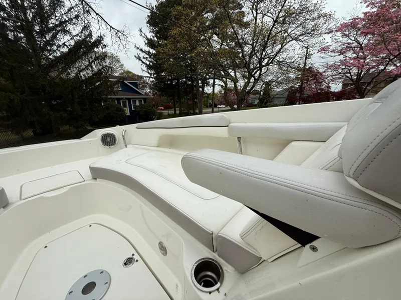Slide: The Image of 2012 Sea Ray 280 Sundeck interior with white seating, surrounded by trees and houses. - 4
