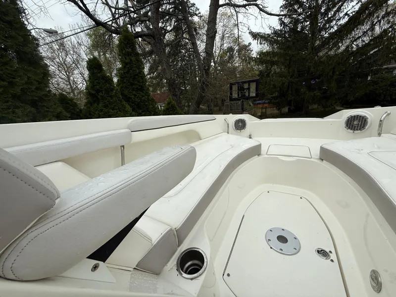 Slide: The Image of 2012 Sea Ray 280 Sundeck interior with white seating and cup holders, surrounded by trees. - 5