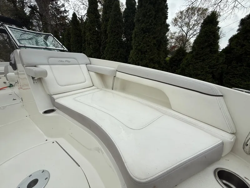 Slide: The Image of 2012 Sea Ray 280 Sundeck boat with white seating and lush greenery background. - 8