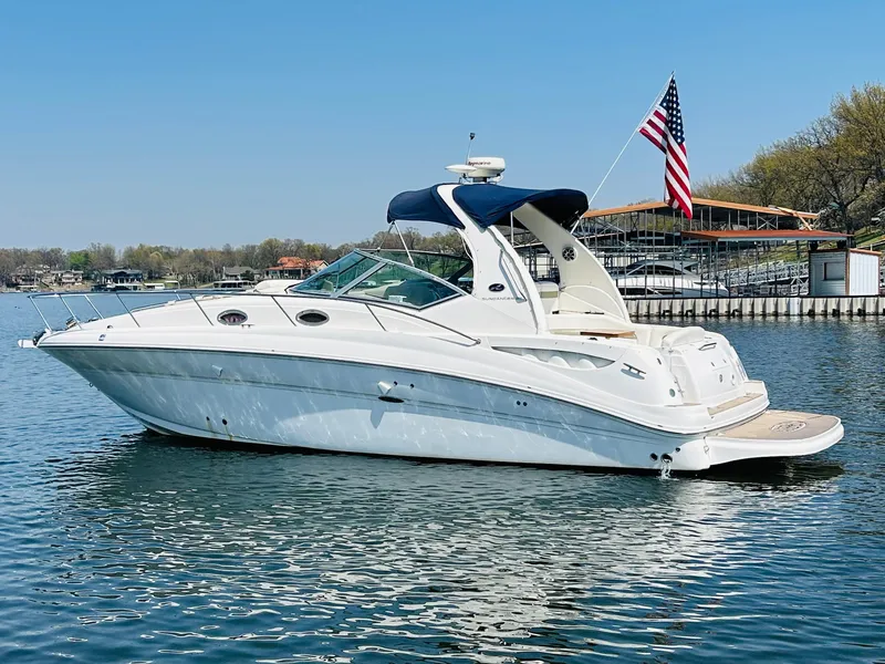 Slide: The Image of 2006 Sea Ray 320 Sundancer boat on calm water with American flag. - 1