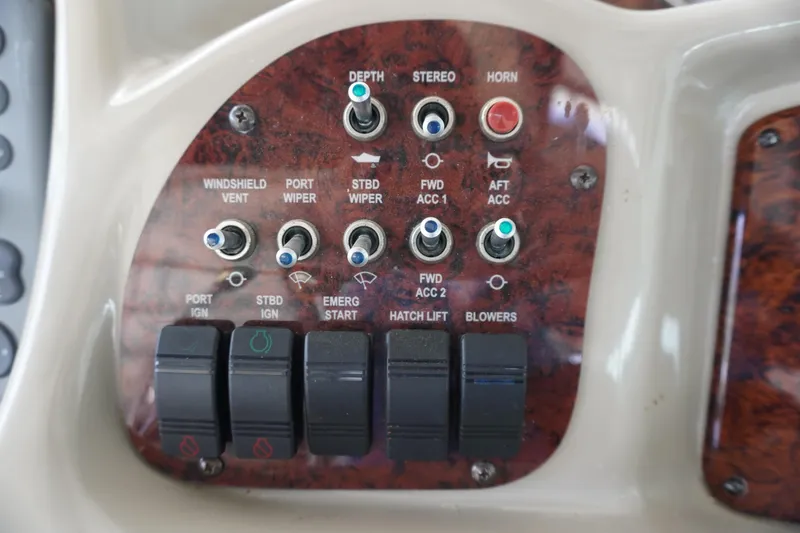 Slide: The Image of Control panel of a 2006 Sea Ray 320 Sundancer boat with various switches and buttons. - 12