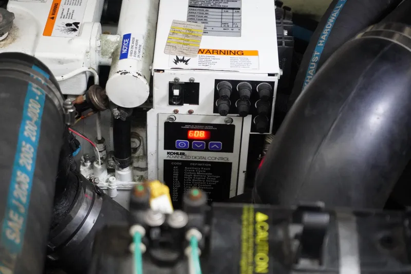 Slide: The Image of Engine compartment of 2006 Sea Ray 320 Sundancer, featuring control panel and warning labels. - 16