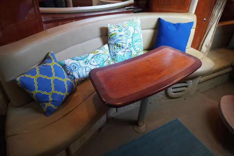Slide: The Image of Interior of 2006 Sea Ray 320 Sundancer with cushioned seating and decorative pillows. - 20