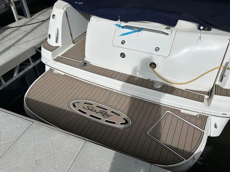 Slide: The Image of 2006 Sea Ray 320 Sundancer swim platform with logo, docked at marina. - 7