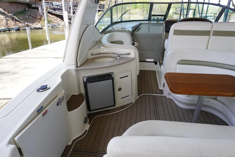Slide: The Image of 2006 Sea Ray 320 Sundancer interior with seating, table, and kitchenette. - 8
