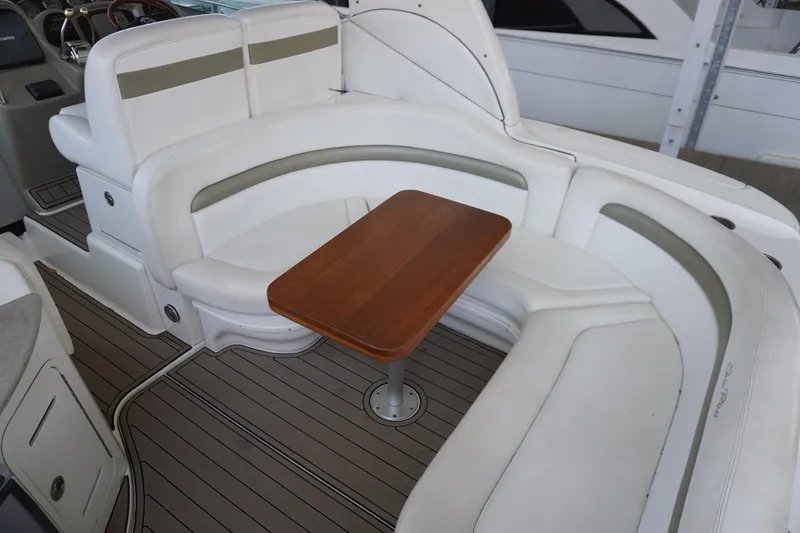 Slide: The Image of 2006 Sea Ray 320 Sundancer interior with white seating and wooden table. - 9