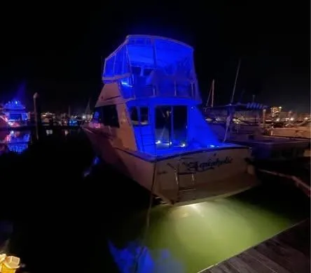 Slide: The Image of 1990 Silverton 40 Convertible yacht illuminated at night in marina. - 11
