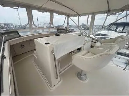 Slide: The Image of 1990 Silverton 40 Convertible yacht interior with helm and seating area. - 14