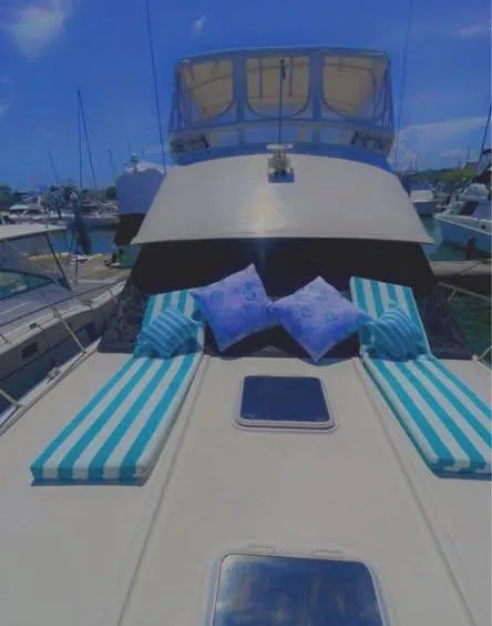 Slide: The Image of 1990 Silverton 40 Convertible yacht with striped cushions and pillows on deck. - 3