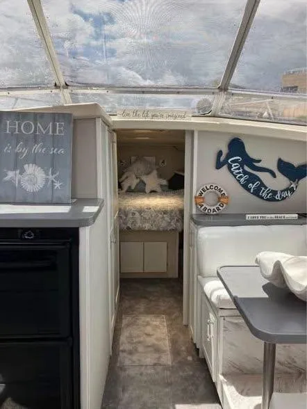 Slide: The Image of Interior of a 1990 Silverton 40 Convertible boat with cozy decor and nautical theme. - 5