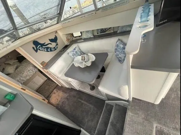 Slide: The Image of 1990 Silverton 40 Convertible interior with cozy seating and nautical decor. - 6