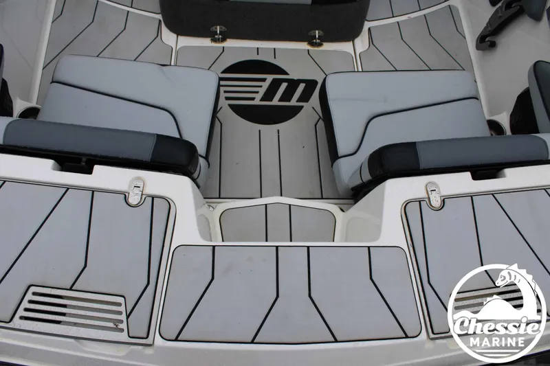 Slide: The Image of 2024 Malibu TXi Mo boat interior with gray seating and Chessie Marine logo. - 16