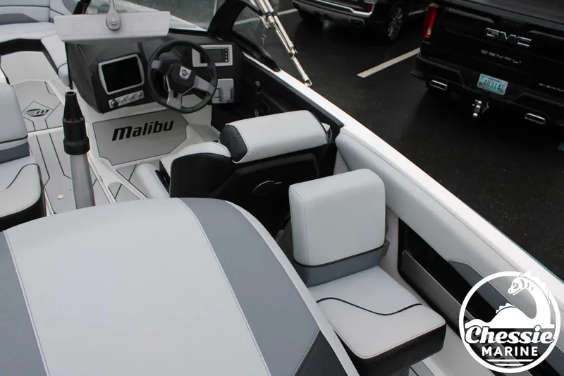 Slide: The Image of 2024 Malibu TXi Mo boat interior with steering wheel and seating, Chessie Marine logo visible. - 24