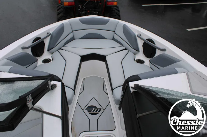 Slide: The Image of 2024 Malibu TXi Mo boat interior with gray seating and Chessie Marine logo. - 26