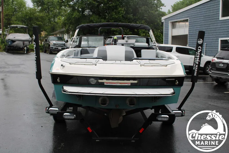 Slide: The Image of 2024 Malibu TXi Mo boat in a parking lot, rear view, Chessie Marine branding. - 4