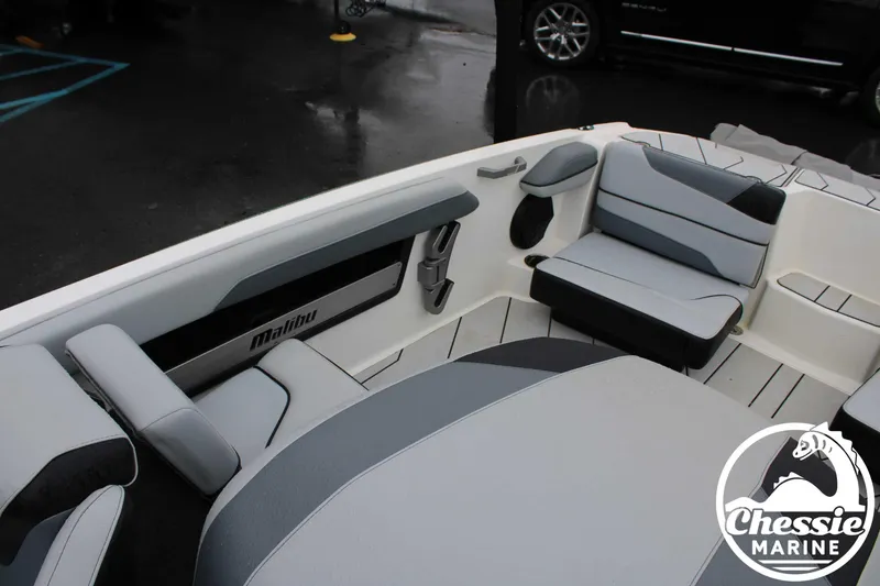 Slide: The Image of 2024 Malibu TXi Mo boat interior with gray seating, branded by Chessie Marine. - 9