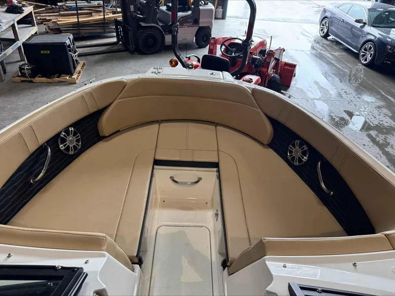 Slide: The Image of 2024 Sea Ray 230SPX boat interior with beige seating and speakers in a garage setting. - 13