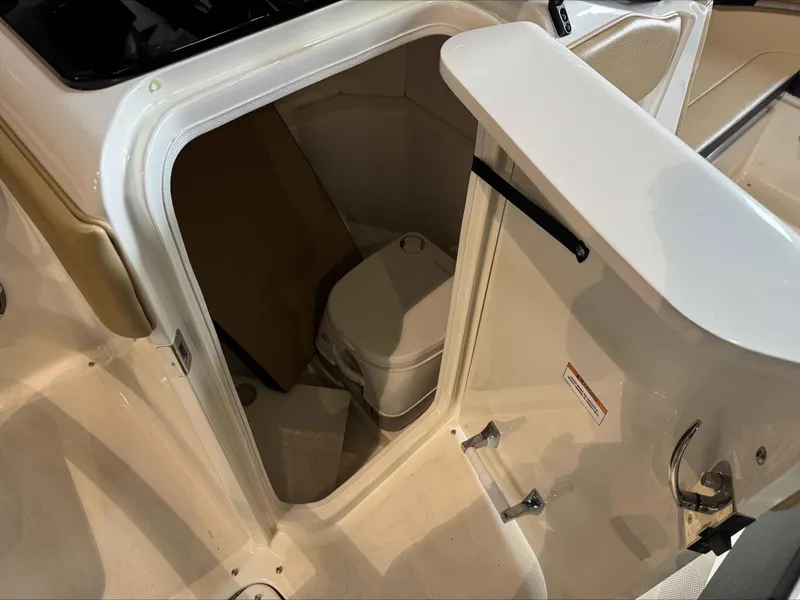 Slide: The Image of 2024 Sea Ray 230SPX boat interior with compact marine toilet compartment. - 15