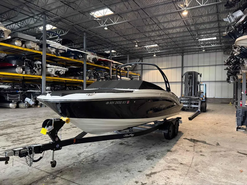 Slide: The Image of 2024 Sea Ray 230SPX boat in storage facility, on trailer, surrounded by other boats. - 3