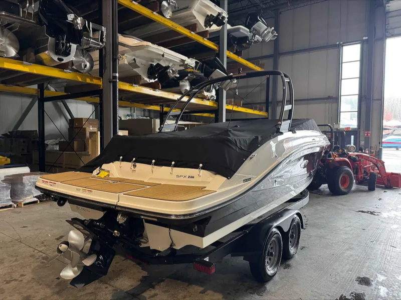 Slide: The Image of 2024 Sea Ray 230SPX boat in warehouse, covered and on trailer. - 5