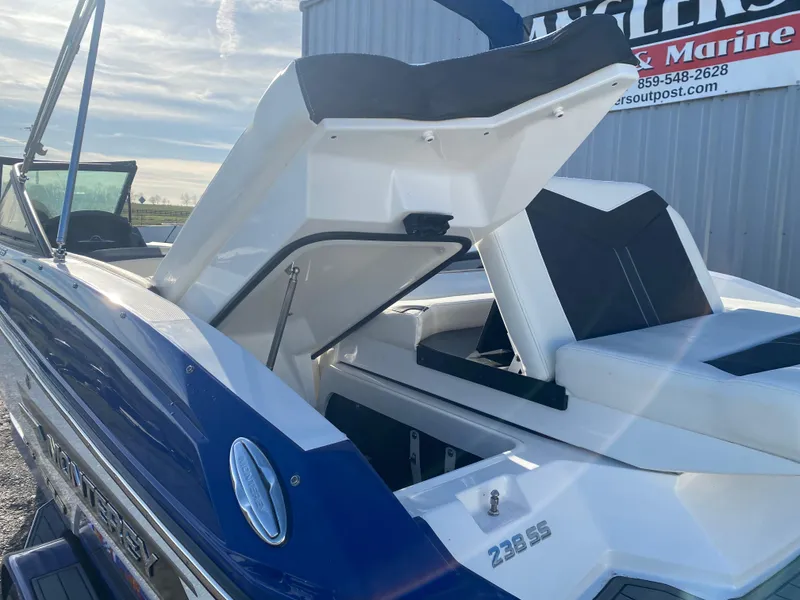 Slide: The Image of 2020 Monterey 238 Super Sport boat with open storage compartment, blue and white design. - 11