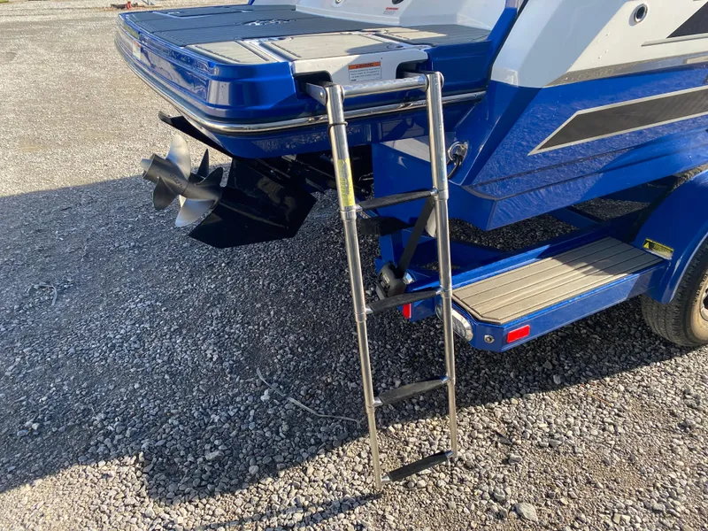 Slide: The Image of 2020 Monterey 238 Super Sport boat with ladder and propeller, parked on gravel. - 8