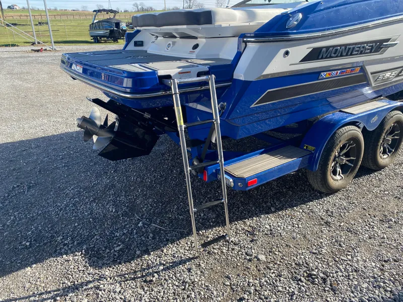 Slide: The Image of 2020 Monterey 238 Super Sport boat with ladder and trailer on gravel surface. - 9