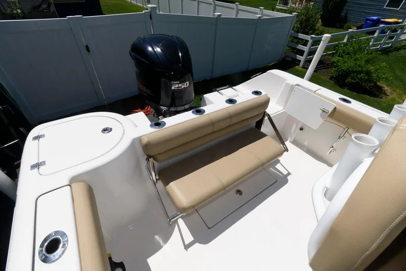 Slide: The Image of 2016 Tidewater 230 CC Adventure boat with seating and outboard motor in a fenced yard. - 11