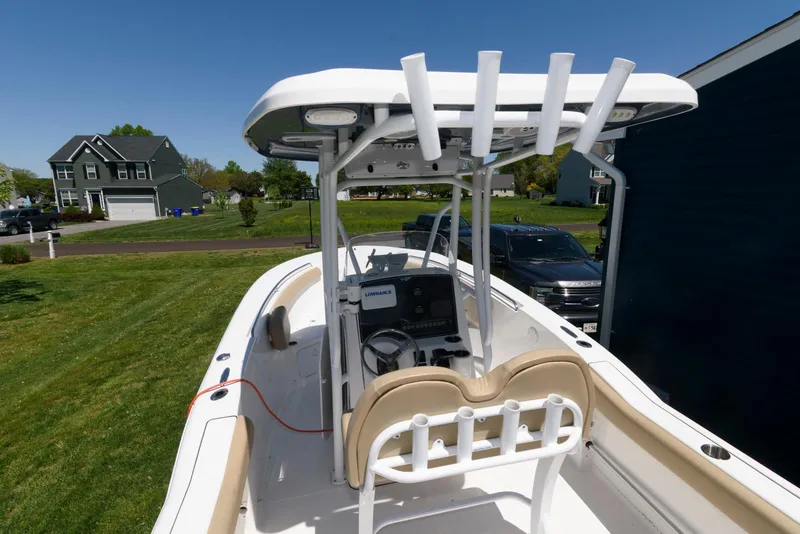 Slide: The Image of 2016 Tidewater 230 CC Adventure boat with T-top and console, parked on grass. - 15
