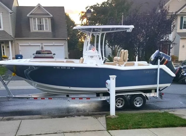Slide: The Image of 2016 Tidewater 230 CC Adventure boat on trailer in suburban neighborhood. - 2