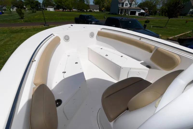 Slide: The Image of 2016 Tidewater 230 CC Adventure boat interior with beige seating and white deck. - 7