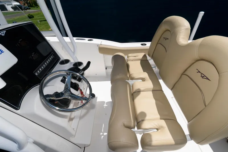 Slide: The Image of 2016 Tidewater 230 CC Adventure boat interior with beige seating and steering console. - 8