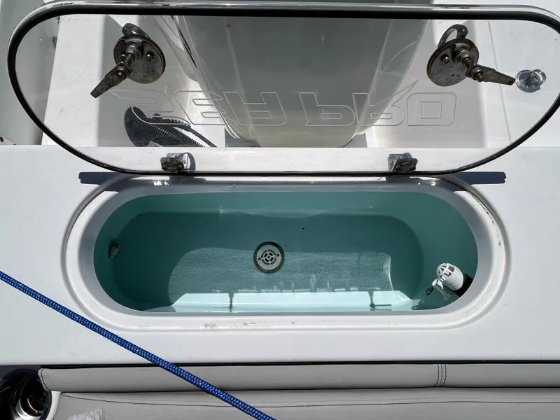 Slide: The Image of 2017 Sea Pro 219 Center Console livewell with open lid and blue interior. - 10