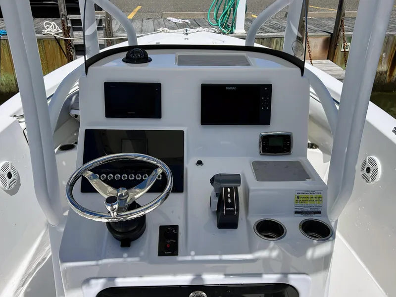 Slide: The Image of 2017 Sea Pro 219 Center Console boat dashboard with steering wheel and navigation controls. - 2